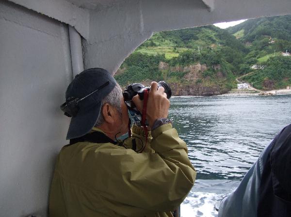 地球の島めぐり_韓国_鬱陵島_身体を壁に固定して撮影する筆者